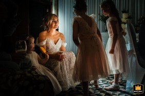 Uma noiva e suas filhas elegantes na recepção de casamento em The Pastures UK, capturando um momento doce juntas com um solero na mão.